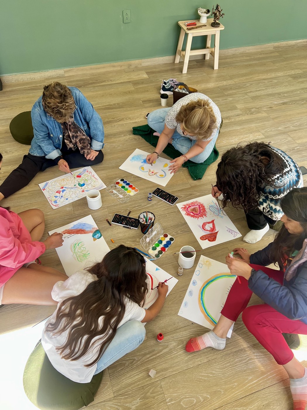 Participantes pintando en el piso durante un taller