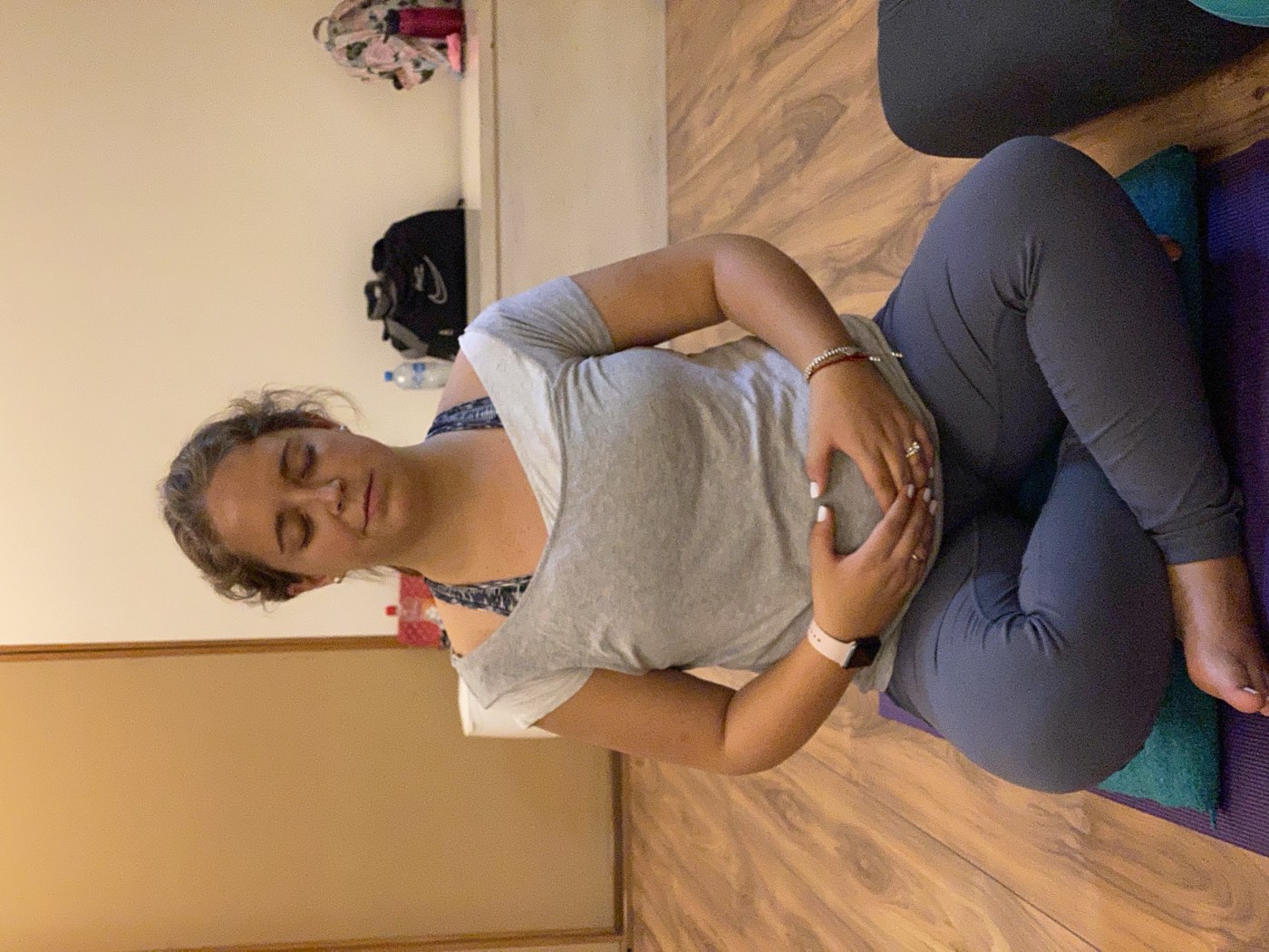 Alumna embarazada meditando con las manos sobre el vientre